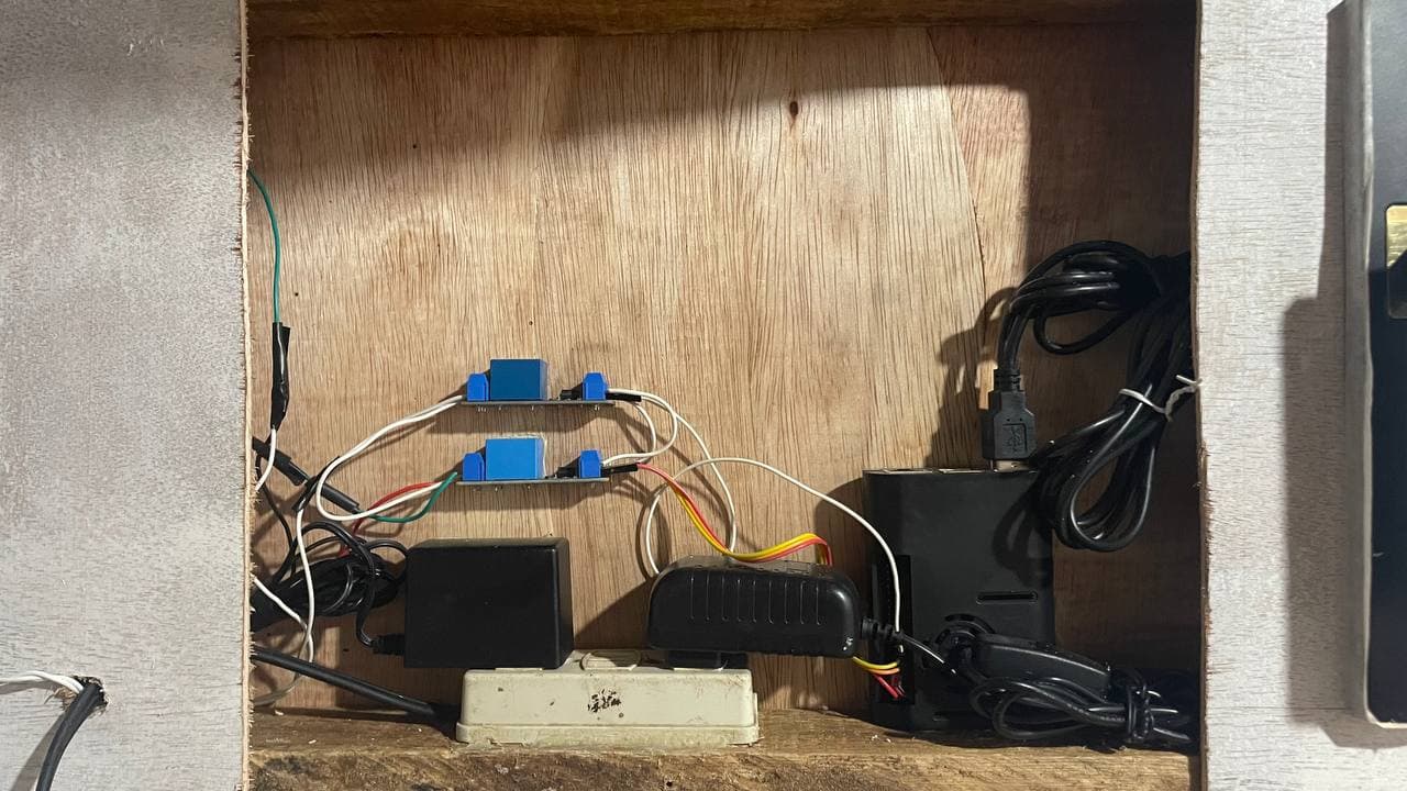 Hardware prototype showing the Raspberry Pi, relay modules, cabling, network hardware, and lock-control components inside the hotel-room model